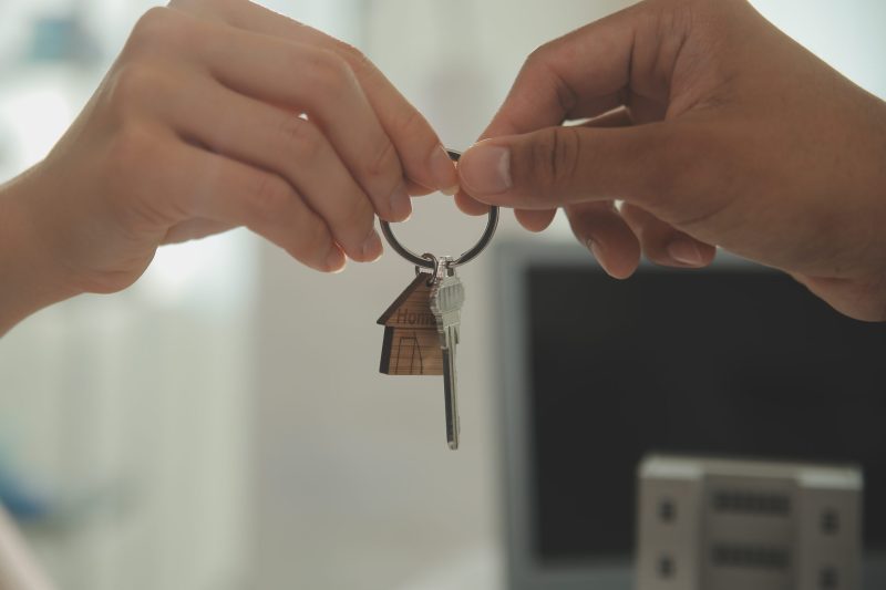 Real estate agent home sales broker is using a pen pointing to the house model and explains the business contract, rent, buy, mortgage, loan, or home insurance